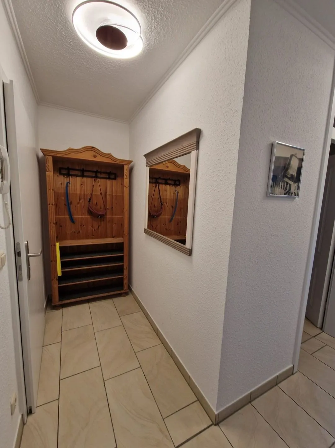 Flur mit Holzgarderobe, Schuhregal und Spiegel