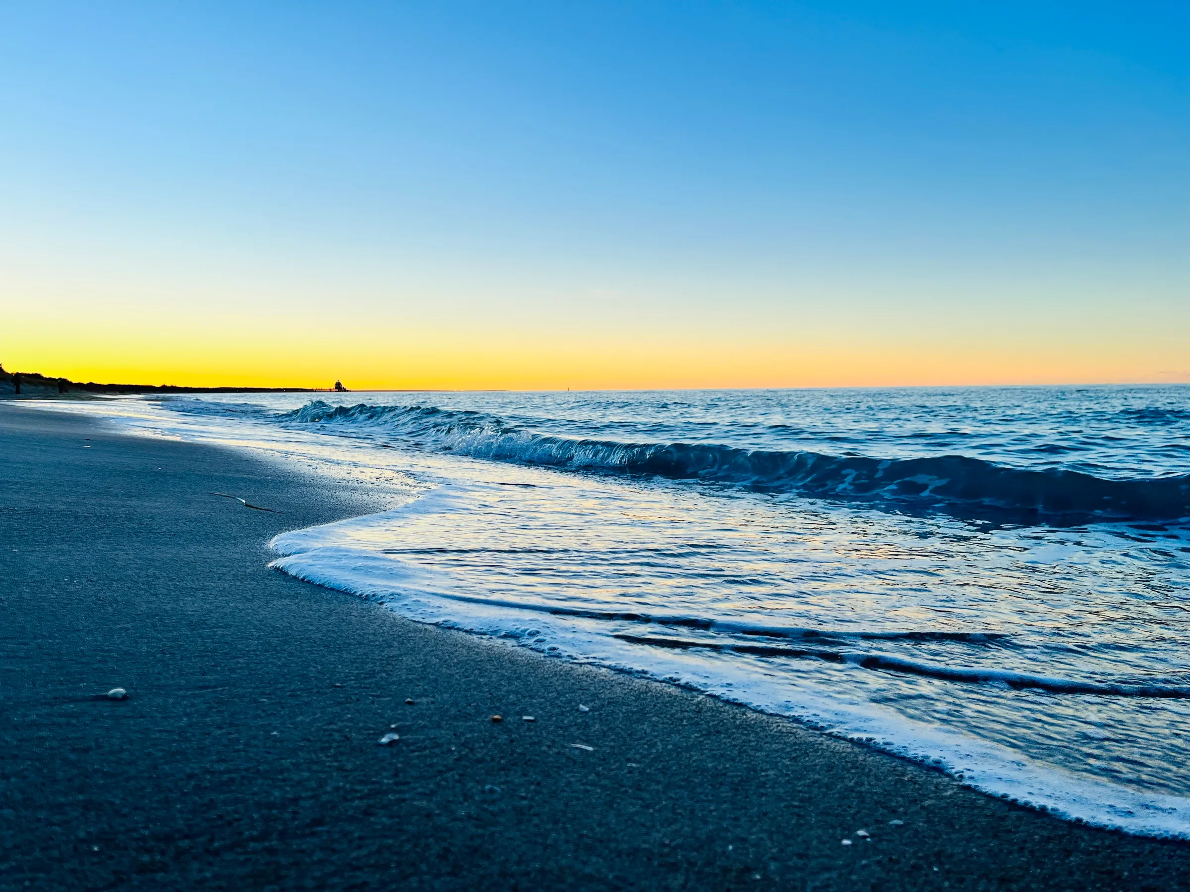 Ostseestrand von Zingst in der Abendsonne, Wellen laufen auf den Sand