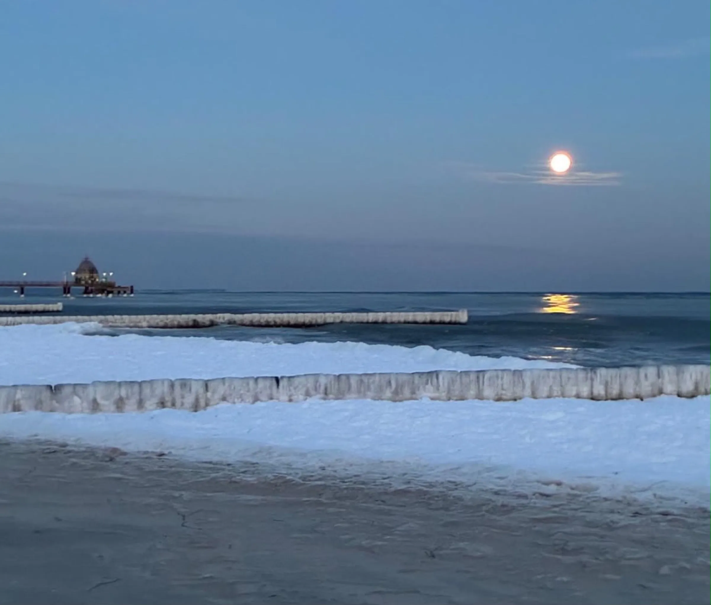 Winterabend am vereisten Strand, Vollmond über der Seebrücke